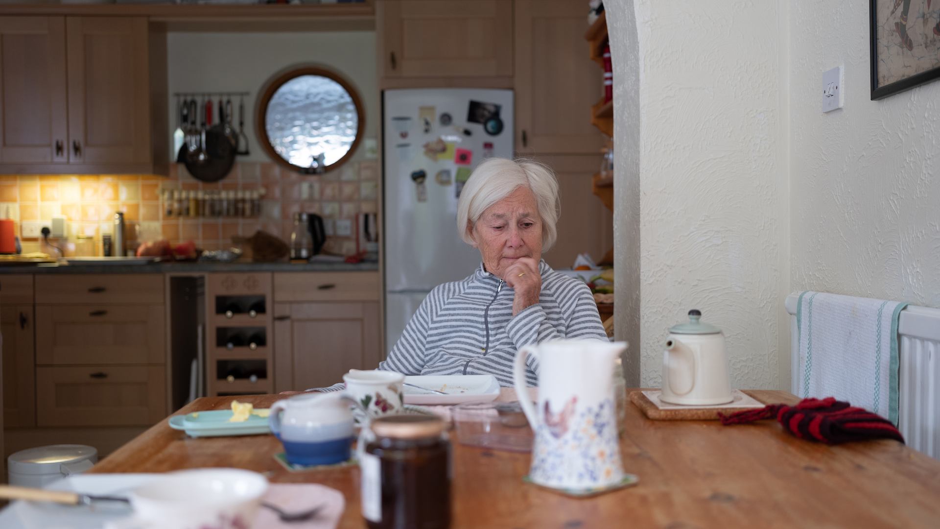 Older woman sitting by a table in her home
