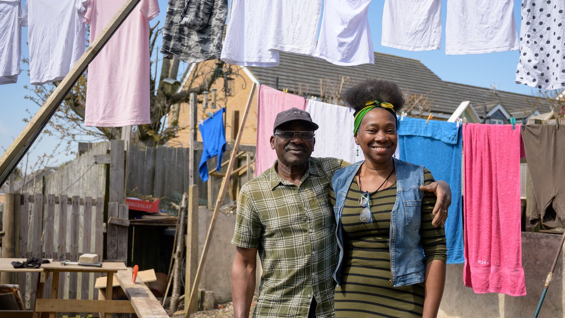 Older man and younger woman smiling in the garden in front of a washing line