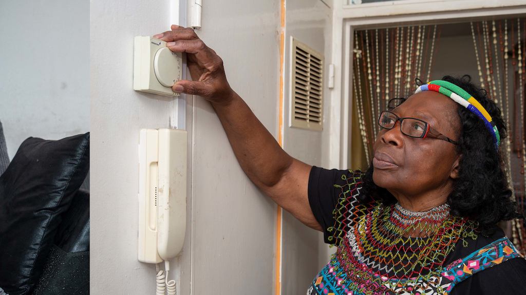 Older woman adjusting her thermostat
