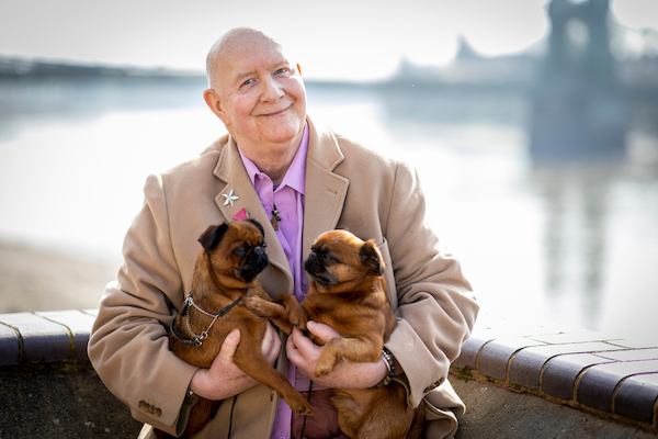 older man outside with two dogs